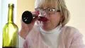 Woman drinks red wine. Depressed senior woman with bottle of wine HD Footage