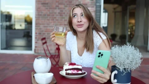 Woman drinks tea during a romantic online date by video call Stock Footage 345029012