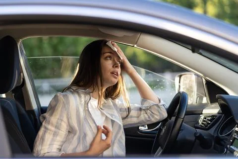 Woman driver being hot during heat wave in car, suffering from hot weather wipes Stock Photos