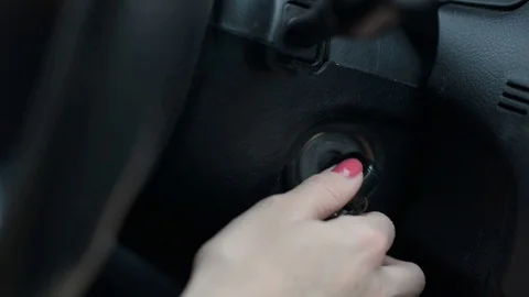 Woman driver hand turn off the key to start car motor Stock Footage