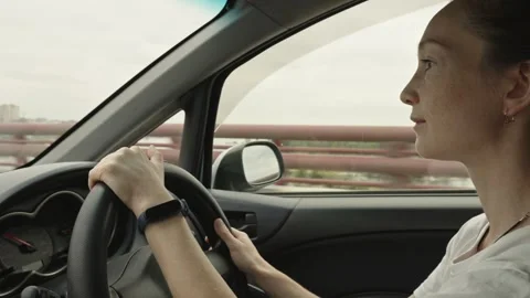 A woman drives a car with her hands on the steering wheel, outside the city  Stock Footage 283472853