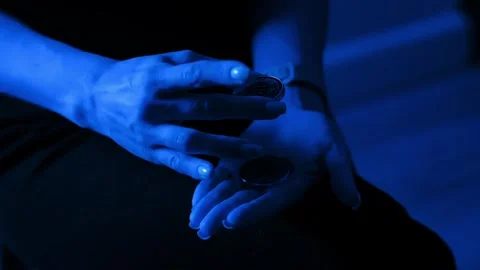 Woman Drops Bitcoin Stack Into Hand – Blue Light Reflects Crypto Uncertainty Stock Footage 321717673