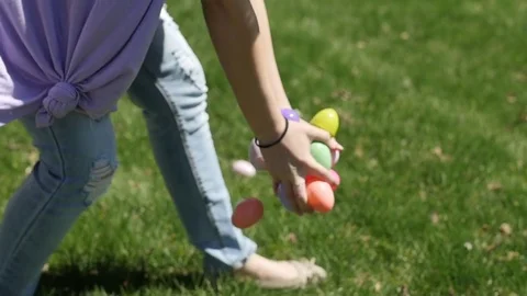Woman Drops Colorful Plastic Easter Eggs On The Grass Stock Footage