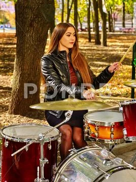 Woman drummer playing drum in autumn park. Stock Photos