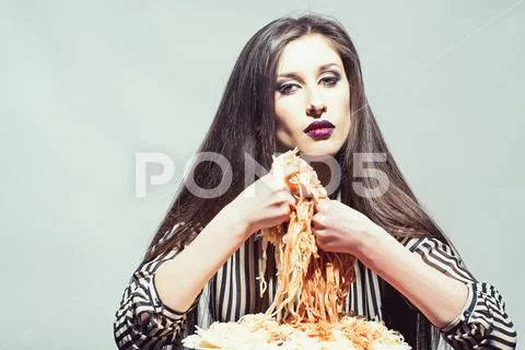 Woman eat pasta dish with tomato ketchup. Sexy woman eat spaghetti with hands Stock Photos