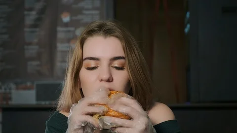 Woman eating a burger Stock Footage