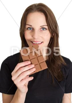 Woman eating chocolate and smiling Stock Photos