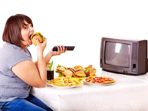 Woman eating fast food and watching tv. Stock Photos