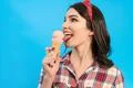 The woman eating an ice cream on the blue background Photo