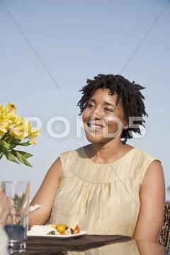 A woman eating a meal on a rooftop terrace Stock Photos