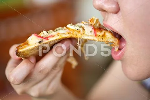 Woman eating piece of seafood pizza Stock Photos