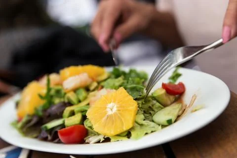 Woman is eating a salad Stock Photos