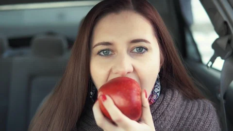 A woman eats an apple in a car Stock Footage 87782149
