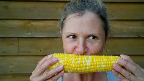 A woman eats a boiled corn cob. Taken in close-up. Stock Footage 250263530