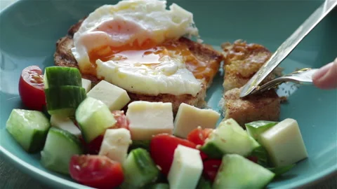 Woman eats breakfast fried egg yolk toast bread fresh salad extreme close view Stock Footage 107386054