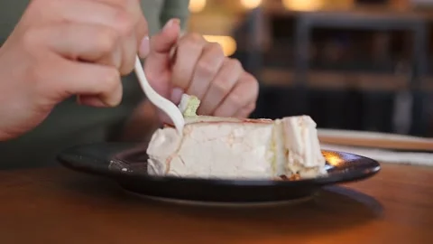 A woman eats in a cafe, breaks off a cake with a fork, puts it in her mouth Video stock 155729619