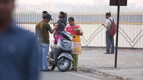 Woman eats corn at sidewalk India Stock Footage 73348069