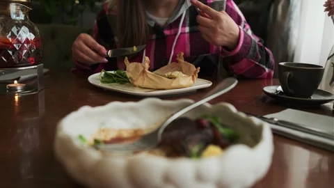 A woman eats Fillet of fragrant cod with mozzarella cheese and red caviar on a Stock Footage 274154330