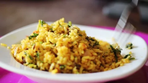 Woman eats with a fork from steaming plate of Nigerian Jollof Rice Vídeos de archivo 58194431