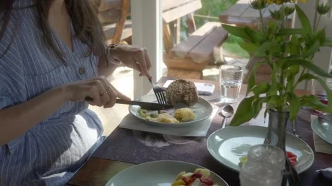 A woman eats ham for breakfast, with an omelet, vegetables, and bread. Stock-Footage 280782371