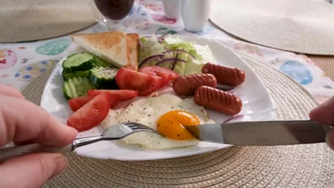 A woman eats her breakfast, scrambled eggs, sausages and toast Vídeos de archivo 332341862