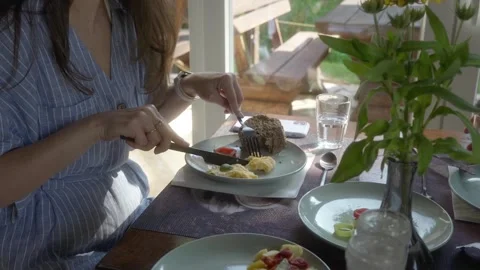 A woman eats an omelet with ham, vegetables, and bread for breakfast. Stock Footage 280782405