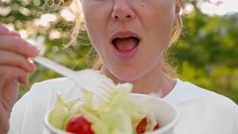 Woman eats salad, made from tomatoes and iceberg lettuce. Stock Footage 274966375
