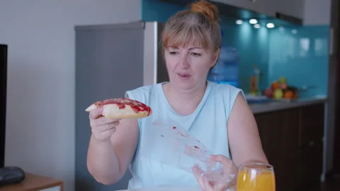 Woman eats a slice of pizza with gusto, takes it out of the box and eats it Stock Footage 319030392
