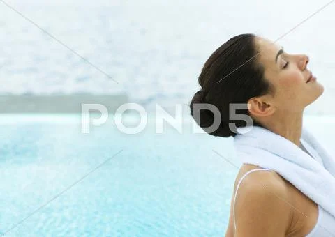 Woman By Edge Of Water With Head Back And Eyes Closed