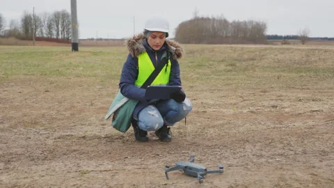 Woman electrical engineer using tablet near drone under high voltage line Stock Footage 151834896