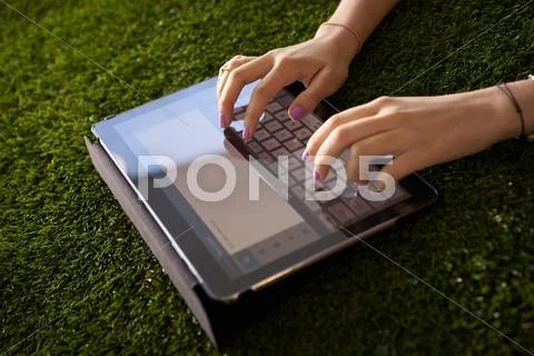 Woman Emailing And Texting With Tablet Computer On Grass Stock Photos