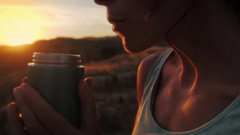 Woman embracing mindful moment while drinking from reusable water bottle in.. Stock Footage 341867383