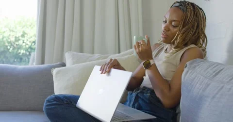 Woman ending work, typing, sipping mug, closing laptop and gazing out window, Stock Footage 337541284