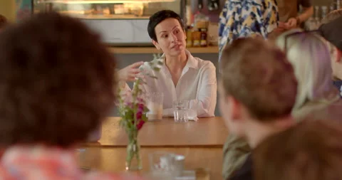 Woman engaged in conversation at cafe table expressing needs opinion. Group Stock Footage 248865087