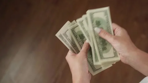 Woman engaged in counting a stack of us dollar bills Stock Footage 284845596