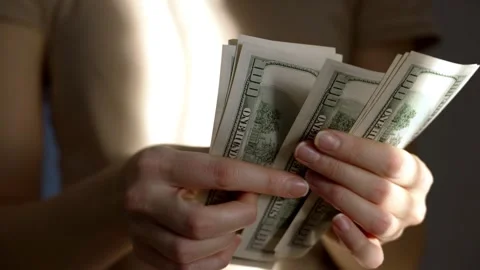 Woman engaged in counting a stack of us dollar bills for financial management Stock Footage 297081568