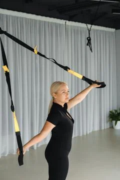 A woman is engaged in strength training, using resistance bands for an upper  Stock Photos