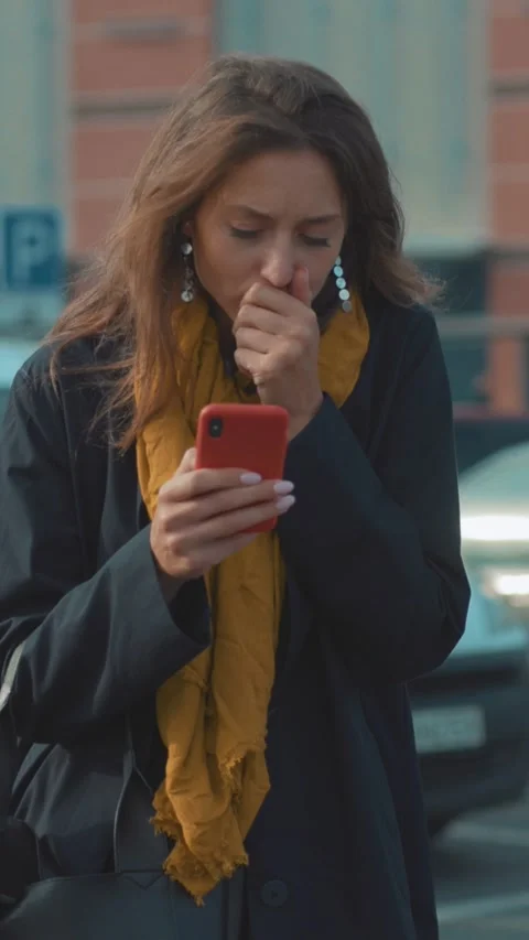 A Woman Engaged in Using Her Smartphone While Walking Through an Urban Stock Footage 314960305