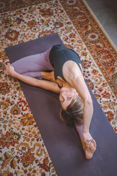 Woman is engaged in yoga. Stretching while looking at the camera. The concept of Stock Photos