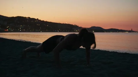 Woman engaging in intense physical exercise on a serene coastal landscape, .. Stock Footage 341867517