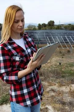 Woman engineer checking solar panel performance on a tablet, monitoring ren.. Stock Photos