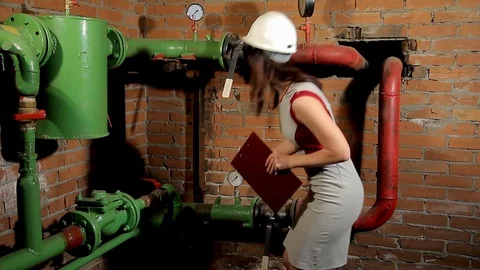 A woman engineer checks the parameters of the heating system. The engineer in 動画素材 76250023