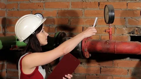 A woman engineer checks the parameters of the heating system. The engineer in 動画素材 76260169