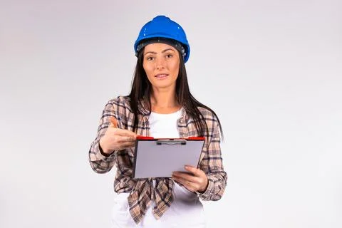Woman engineer with folder posing and smiling at the camera. Gray background Stock-Fotos
