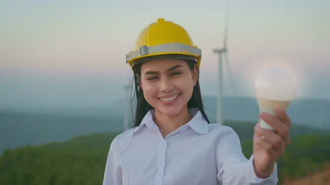 A woman engineer is holding Light bulb wearing a protective helmet on her hea Vídeos de archivo 149050182