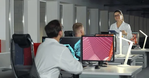 Woman engineer in lab coat instructing apprentices in office Stock Footage 126640189