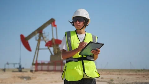 Woman engineer making digital notes at oil pump site Stock Footage 317265066