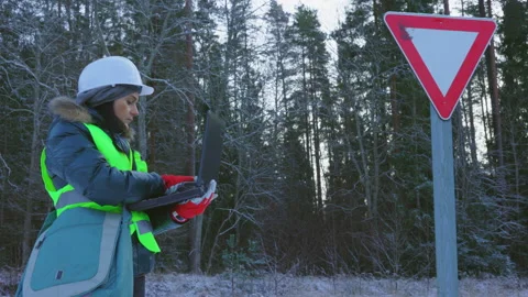 Woman engineer planning temporary movement of road signs on the forest road Stock Footage 145805720