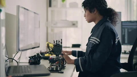 Woman engineer programming robotic arm prototype with computer. Stock Footage 319001453