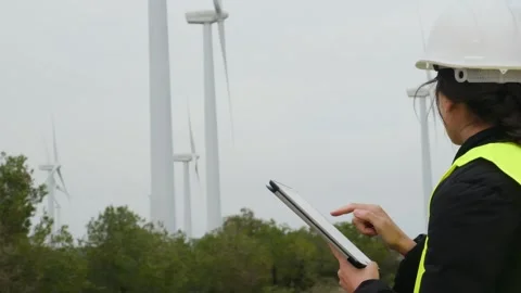 Woman engineer with tablet computer working with wind turbines Stock Footage 270455596